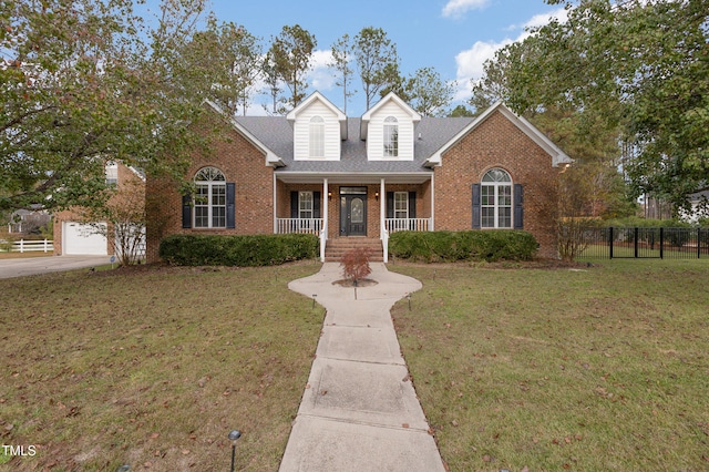 view of property featuring a porch, a garage, and a front lawn