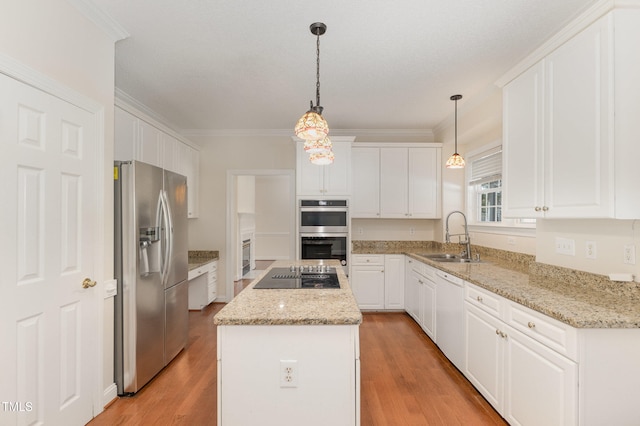 kitchen with white cabinetry, sink, stainless steel appliances, and decorative light fixtures