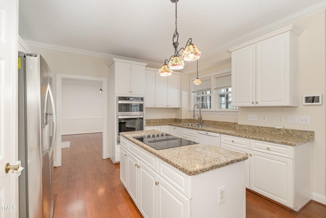 kitchen featuring pendant lighting, a center island, stainless steel appliances, and white cabinetry