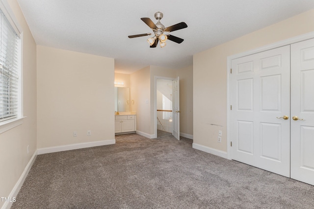 unfurnished bedroom with ceiling fan, light carpet, connected bathroom, and a closet