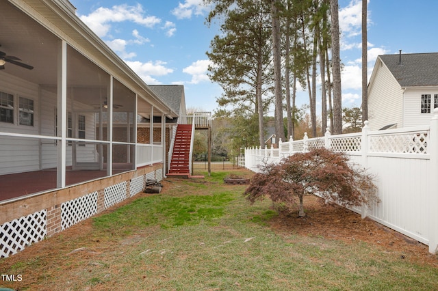 view of yard with a sunroom and ceiling fan