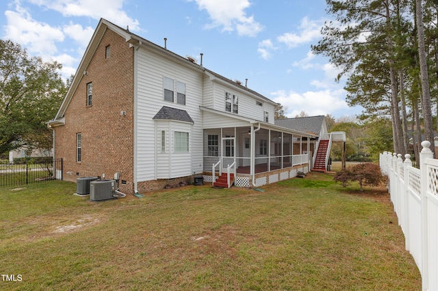 back of property with a yard, central AC unit, and a sunroom