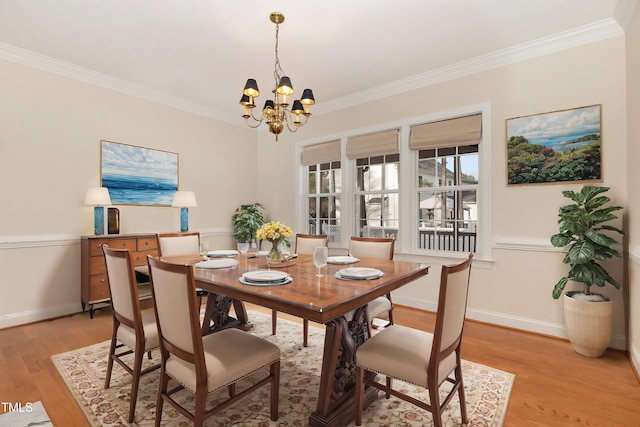 dining area featuring light hardwood / wood-style floors, ornamental molding, and an inviting chandelier