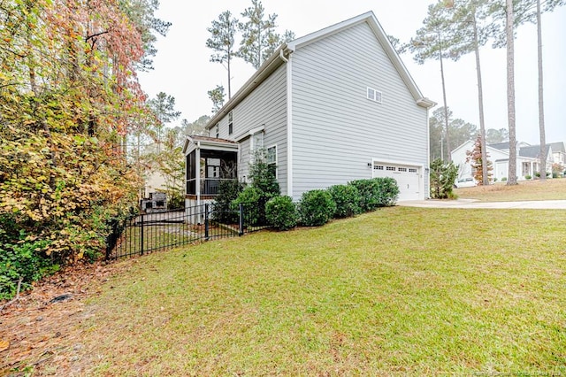 view of property exterior featuring a garage, a yard, and a sunroom