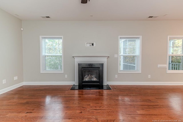 unfurnished living room with a wealth of natural light and hardwood / wood-style floors