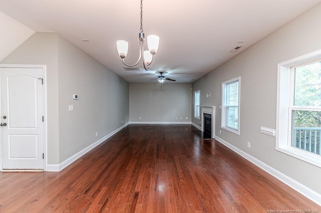 unfurnished living room with a healthy amount of sunlight, dark hardwood / wood-style floors, and ceiling fan with notable chandelier