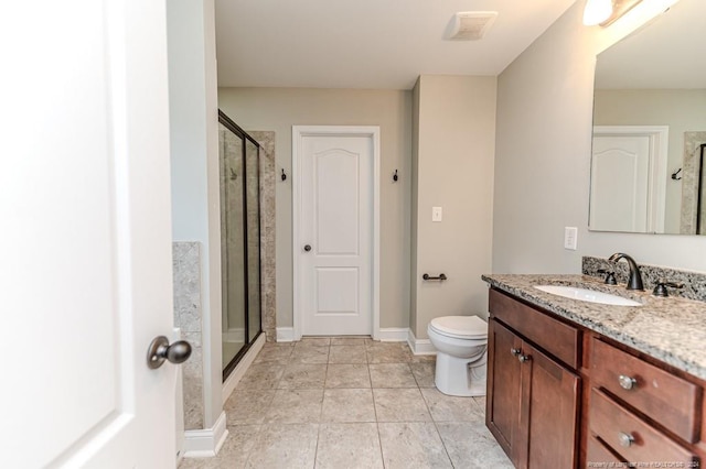 bathroom featuring a shower with shower door, vanity, toilet, and tile patterned flooring