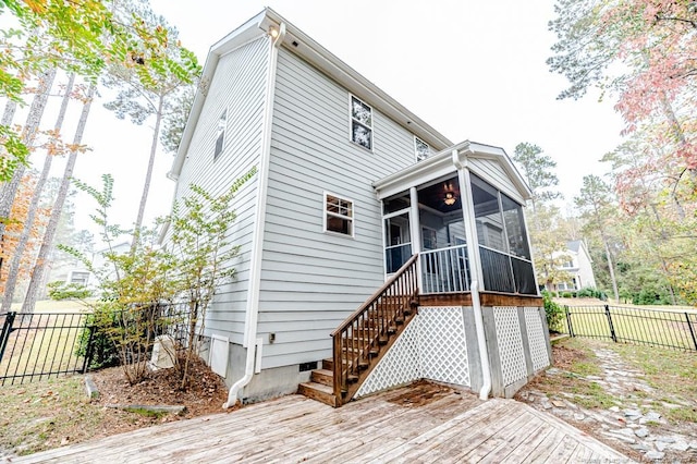 rear view of house with a sunroom and a wooden deck