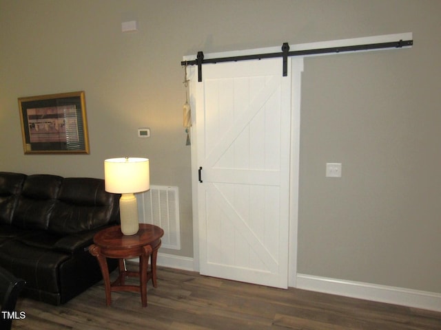 living area featuring dark wood-type flooring and a barn door