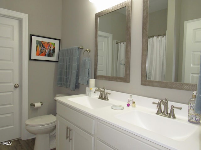 bathroom with curtained shower, wood-type flooring, vanity, and toilet