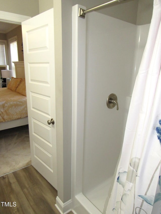 bathroom with hardwood / wood-style flooring and a shower with curtain