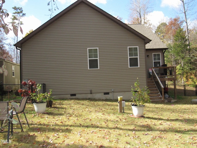 back of house featuring a deck and a lawn