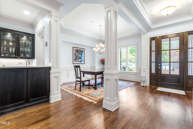 entryway with dark hardwood / wood-style flooring, decorative columns, and ornamental molding