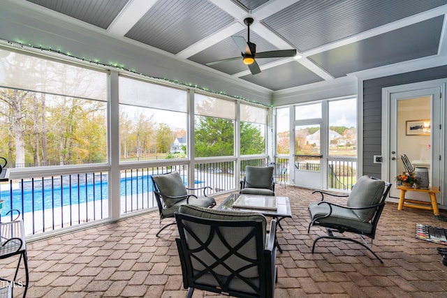 sunroom / solarium with coffered ceiling, ceiling fan, a healthy amount of sunlight, and beam ceiling