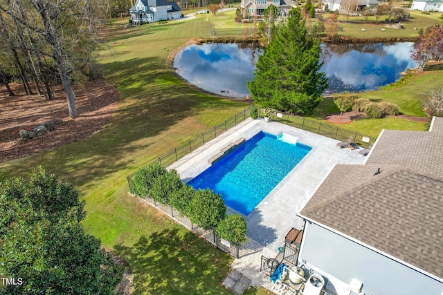 view of pool with a patio area, a water view, and a lawn