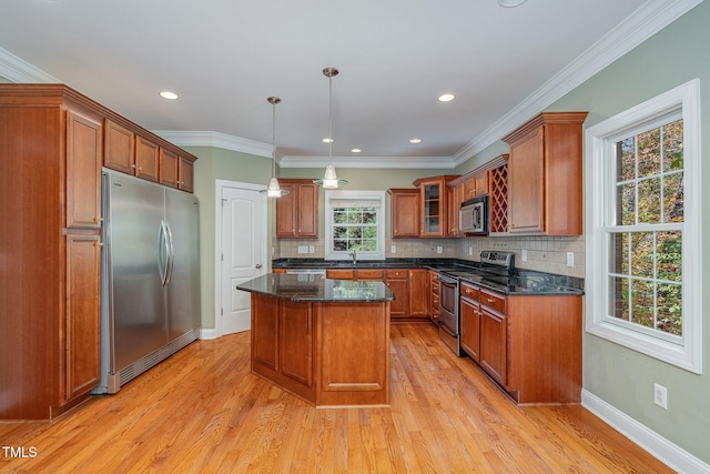 kitchen featuring a wealth of natural light, light hardwood / wood-style flooring, appliances with stainless steel finishes, and a center island