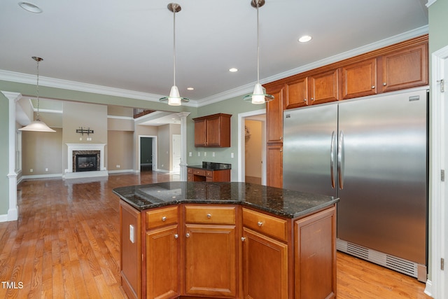 kitchen featuring pendant lighting, stainless steel built in fridge, a center island, and light hardwood / wood-style flooring