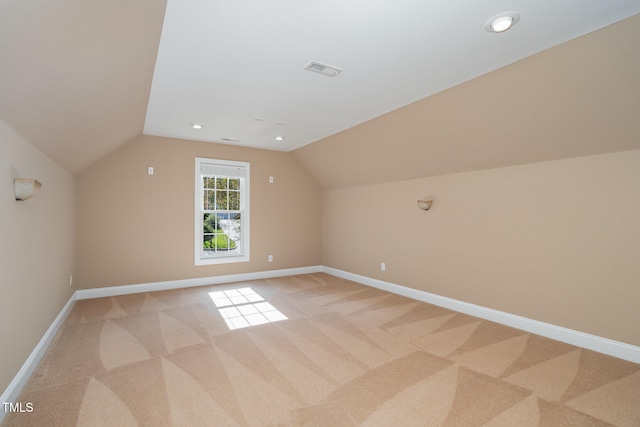 additional living space featuring light carpet and lofted ceiling