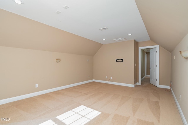 bonus room with lofted ceiling and light colored carpet