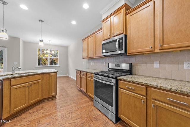 kitchen featuring an inviting chandelier, light stone counters, light hardwood / wood-style flooring, pendant lighting, and appliances with stainless steel finishes