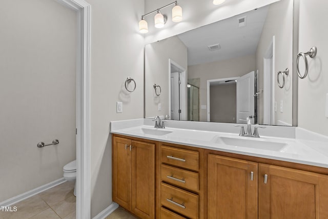 bathroom featuring tile patterned flooring, vanity, toilet, and a shower with door