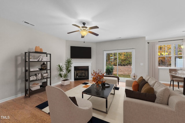 living room with ceiling fan and light wood-type flooring