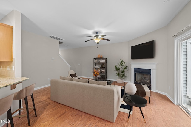 living room with light hardwood / wood-style floors and ceiling fan