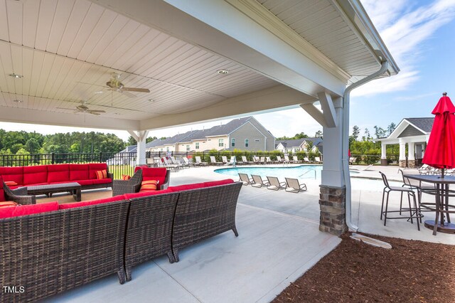 view of patio / terrace featuring an outdoor living space, ceiling fan, and a community pool