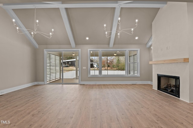 unfurnished living room featuring a fireplace, wood finished floors, a notable chandelier, and beamed ceiling