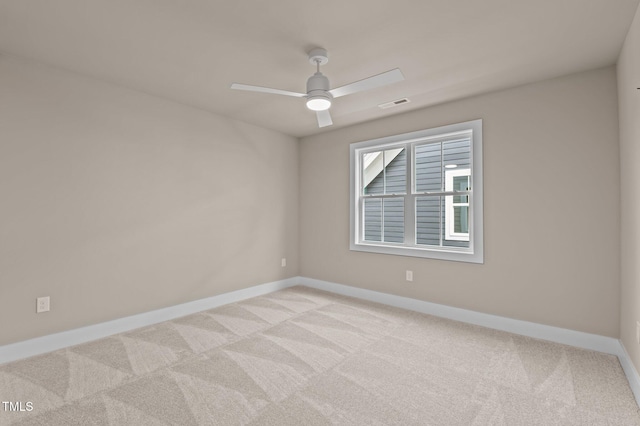 unfurnished room with light carpet, baseboards, visible vents, and ceiling fan