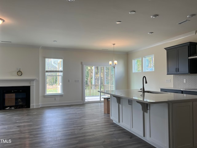 kitchen featuring a healthy amount of sunlight, sink, dark hardwood / wood-style flooring, and ornamental molding