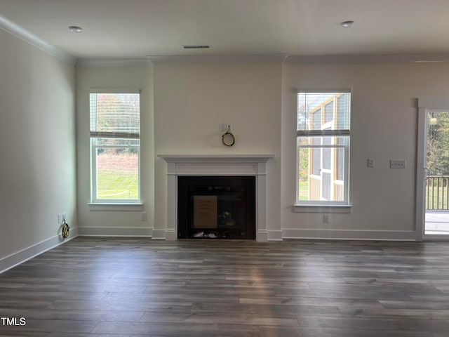 unfurnished living room featuring crown molding, a healthy amount of sunlight, and dark hardwood / wood-style floors