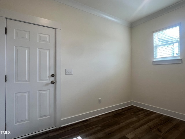 empty room featuring dark hardwood / wood-style flooring and ornamental molding