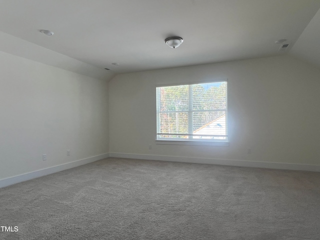 empty room featuring lofted ceiling and carpet floors