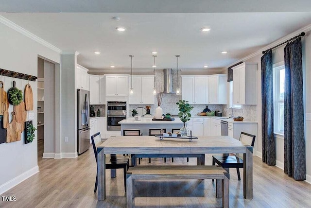 dining space with ornamental molding, light wood-type flooring, and sink