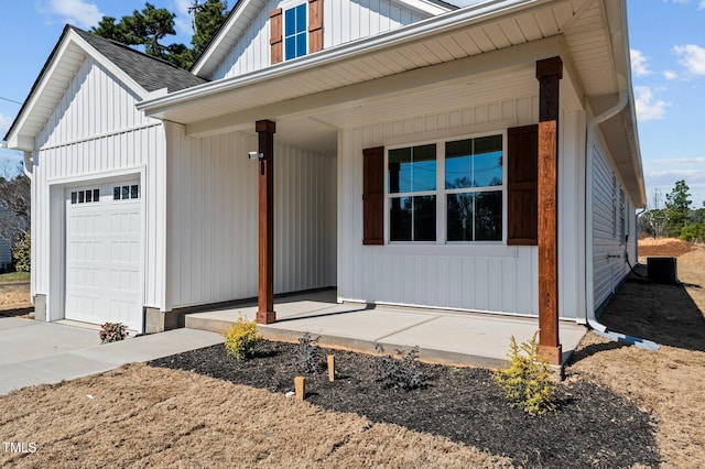 modern farmhouse with a porch, central AC, roof with shingles, board and batten siding, and an attached garage