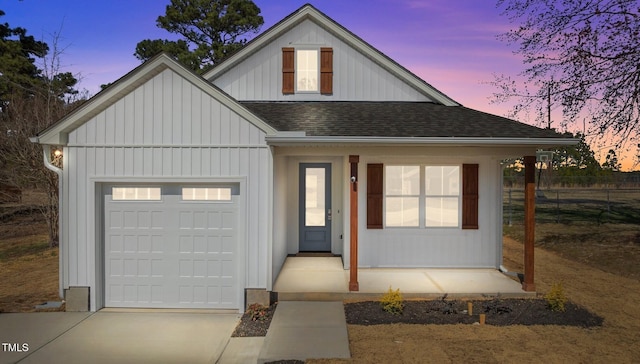 view of front of home featuring board and batten siding, fence, roof with shingles, driveway, and an attached garage