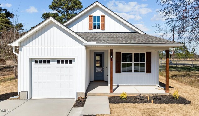 modern farmhouse style home featuring board and batten siding, fence, concrete driveway, roof with shingles, and a garage