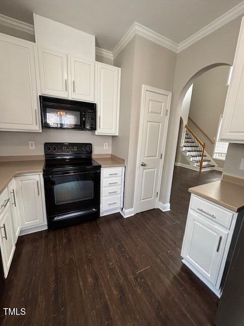 kitchen featuring white cabinets, ornamental molding, black appliances, and dark hardwood / wood-style floors