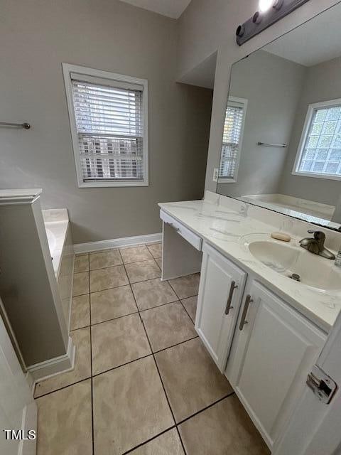 bathroom with vanity, tile patterned floors, and a bath