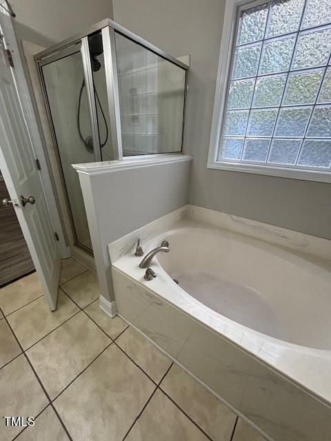 bathroom with independent shower and bath and tile patterned floors