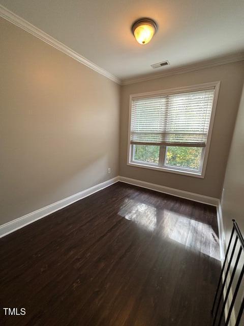 spare room featuring dark hardwood / wood-style flooring and ornamental molding