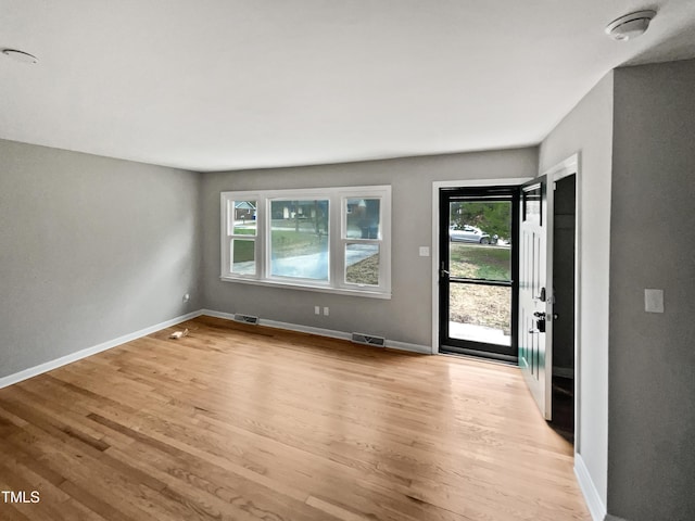 interior space featuring light wood-style flooring, baseboards, and visible vents