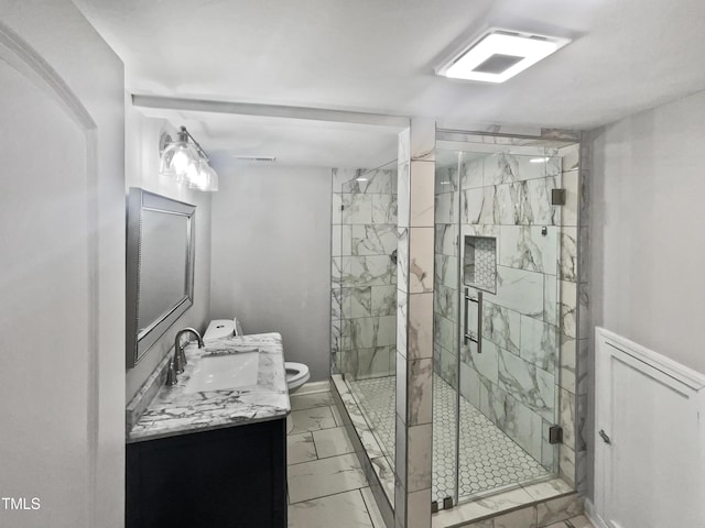 bathroom featuring vanity, toilet, a shower stall, and marble finish floor