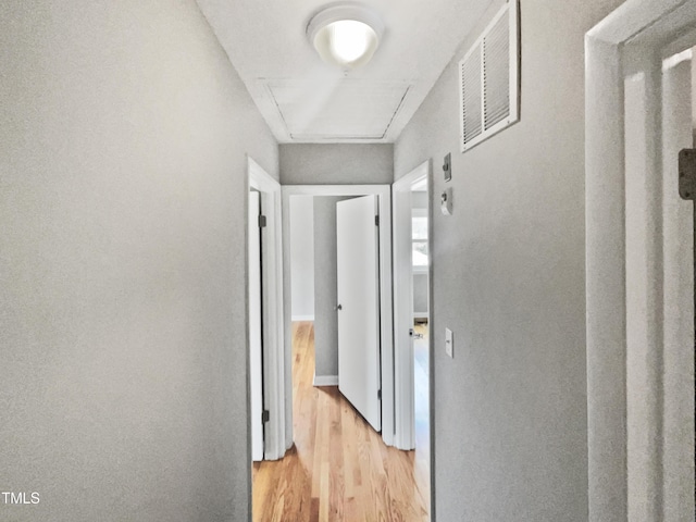 hallway with light wood-style floors and visible vents