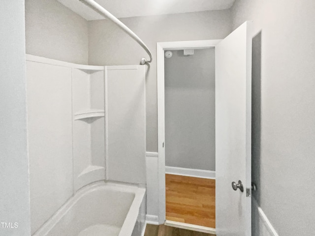full bathroom with wood finished floors and washtub / shower combination