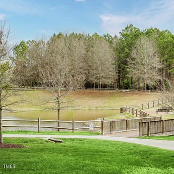 view of community with a yard, a water view, and a rural view