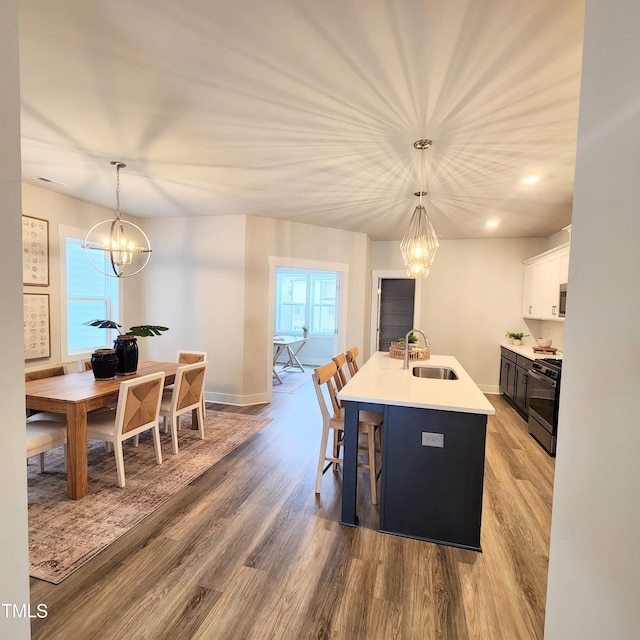 dining space featuring sink, an inviting chandelier, and light hardwood / wood-style flooring