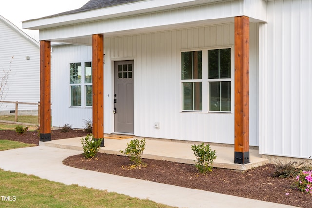 view of exterior entry featuring covered porch