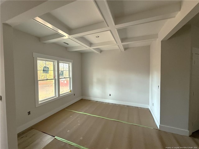 empty room featuring beamed ceiling, coffered ceiling, and hardwood / wood-style floors